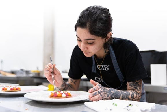 Alumna amb un pastís en el curs de xef especialista en patisseria CIB