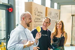A professional chef interacting with students in a modern facility, representing management and global vision in the culinary business.